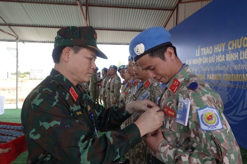 Lieutenant General Pham Truong Son presents the medal to Vietnamese peacekeepers.