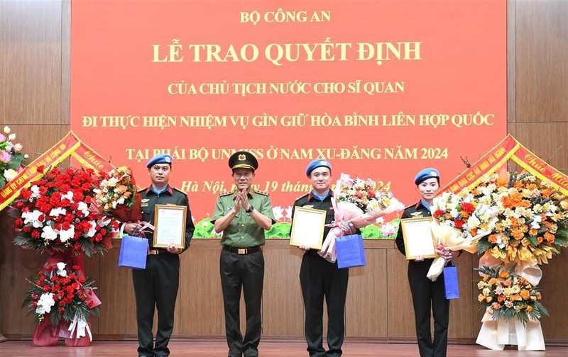 Authorised by the President, Minister of Public Security Sen. Lieut. Gen. Luong Tam Quang presents the decisions to the three officers (Photo: VNA)