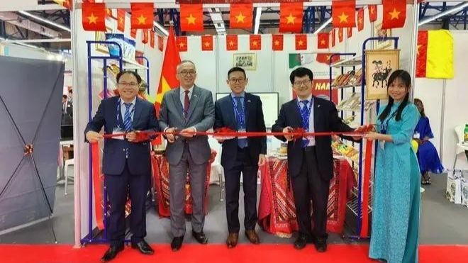 Ambassador Tran Quoc Khanh (middle) and trade counselor Hoang Duc Nhuan (left) cut the ribbon to launch the Vietnam pavilion at the fair. (Photo: VNA) 