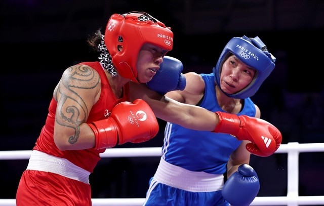 Ha Thi Linh of Vietnam (right) lands a punch on Feofaaki Epenisa from Tonga during the Paris Olympics' women's 60kg first round match on July 27. (Photo: doisongphapluat.com.vn)