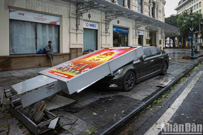 A car is damaged by a falling billboard. (Photo: Duy Linh)