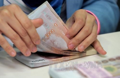 Counting Thai baht at Krung Thai Bank in Bangkok. (Photo: AFP/VNA)