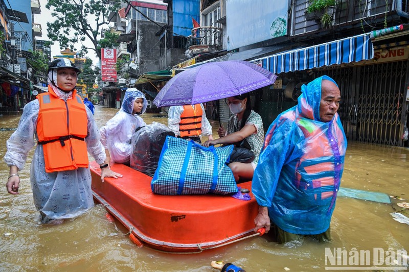 People are evacuated from a flooded area in Hanoi.