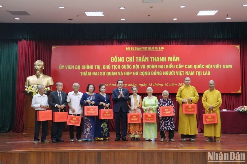 NA Chairman Tran Thanh Man presents gifts to members of the Vietnamese community in Laos. (Photo: NDO)