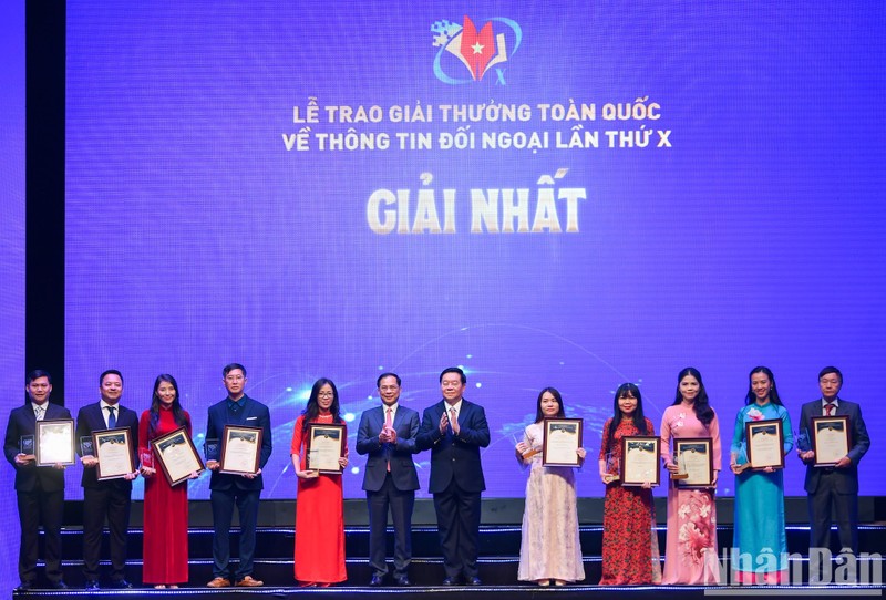 Politburo member, Secretary of the Party Central Committee and Chairman of its Commission for Information and Education Nguyen Trong Nghia and Deputy Prime Minister and Minister of Foreign Affairs Bui Thanh Son present awards to authors and groups of authors that win the first prize. (Photo: Thanh Dat)