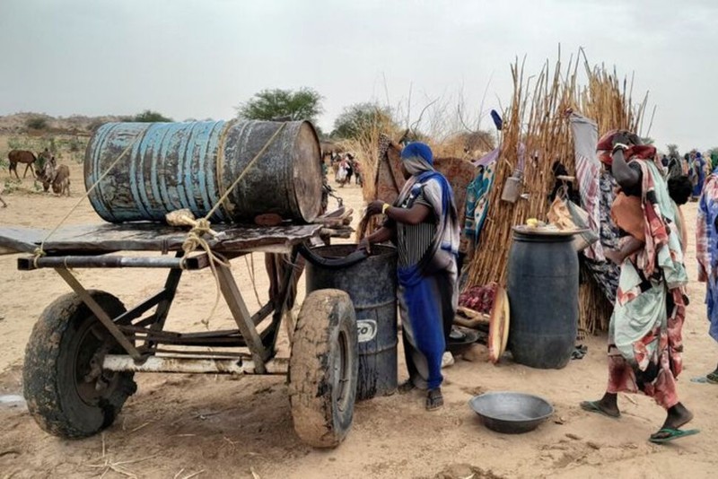 A Sudanese woman, who fled the violence in her country, tries to get water from a barrel near the border between Sudan and Chad in Adre, Chad April 26, 2023. (Photo: Reuters)