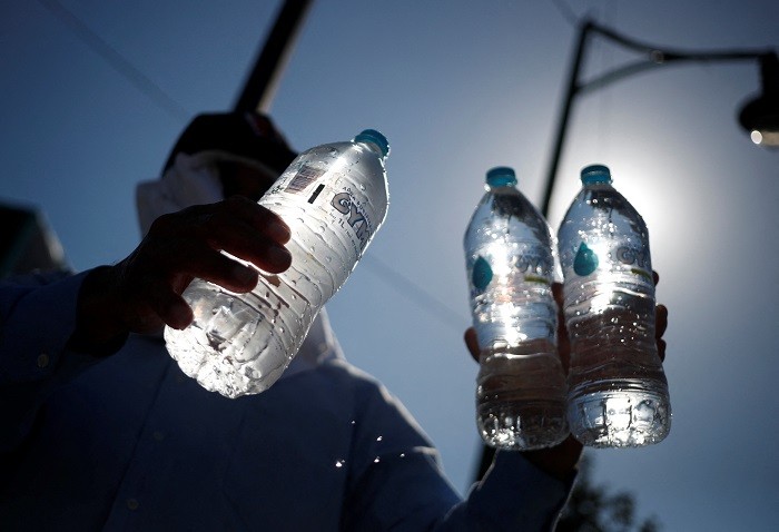 A man sells bottled water during a red traffic light as high temperatures continue, in Monterrey, Mexico, June 28, 2023. (Photo: Reuters)