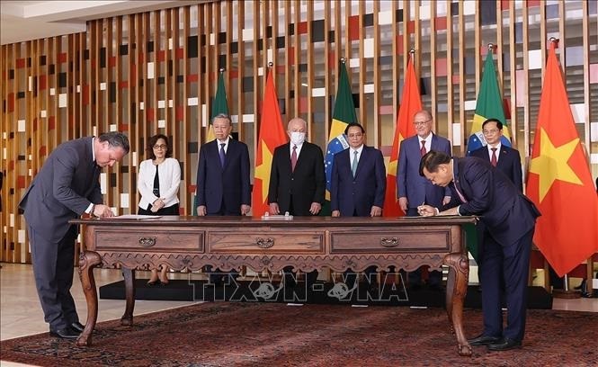 Brazillian President Lula da Silva and Vietnamese Prime Minister Pham Minh Chinh witness the signing of a memorandum of understanding on agricultural cooperation between the two countries‘s ministries. (Photo: VNA)