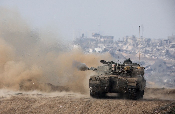 An Israeli tank fires towards Gaza, amid the ongoing conflict between Israel and the Palestinian Islamist group Hamas, at the Israel-Gaza border, in southern Israel, December 27, 2023. (Source: Reuters)