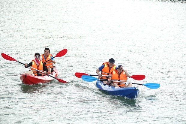 Visitors kayak around Banh Sua island. (Photo: Vietnam Pictorial)