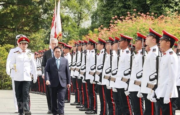 PM Pham Minh Chinh and his Singaporean counterpart Lee Hsien Loong inspect guards of honour (Photo: VNA)