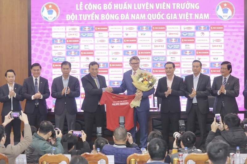 VFF President Tran Quoc Tuan (fourth from left) presents a bouquet and a shirt to head coach Philippe Troussier at the ceremony. (Photo: VNA)