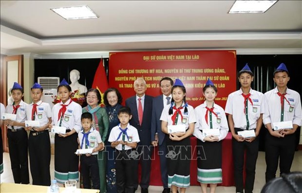 The president of the Vu A Dinh scholarship fund and former Vice State President Truong My Hoa (4th from left) and officials give scholarships to disadvantaged oversea-Vietnamese students in Laos. (Photo: VNA)A delegation from Vu A Dinh Scholarship Fund and Club “For Beloved Hoang Sa and Truong Sa archipelagos” and the Vietnamese Embassy in Laos on March 14 organised a ceremony to give 100 scholarships worth a total of 5,000 USD to disadvantaged oversea-Vietnamese students with outstanding study performance.