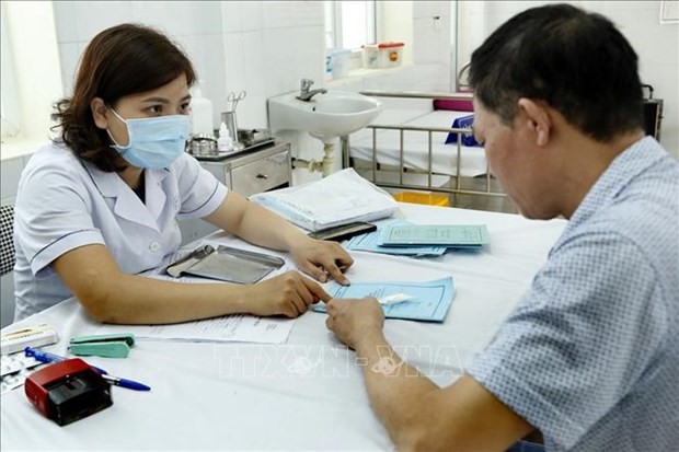 A medical worker gives advice to a resident in Hanoi. (Photo: VNA)