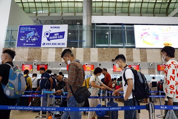 Passengers wait to handle boarding procedures at the Noi Bai International Airport. (Photo: VNA)