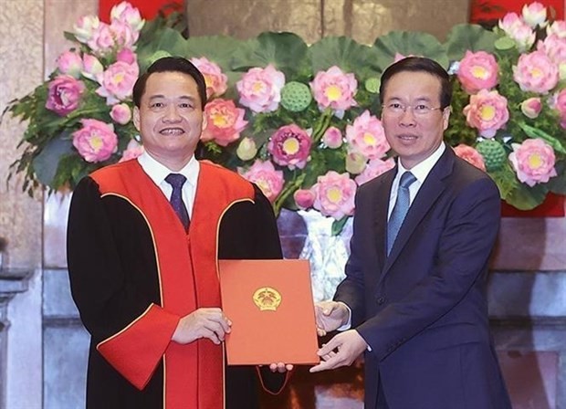 President Vo Van Thuong (R) hands over a decision on the appointment of Nguyen Hong Nam, Senior Judge and Deputy Chief Justice of the High-level People's Court in Hanoi as Judge of the Supreme People’s Court. (Photo: VNA)