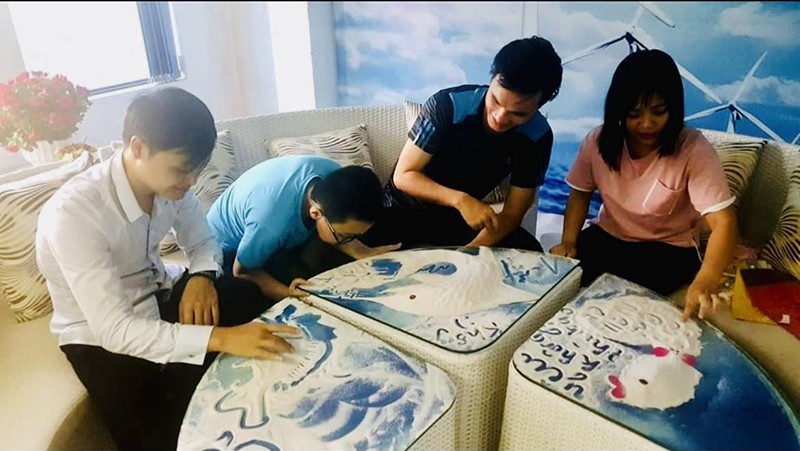 Tourists experience sandpainting at S-Happy Coffee