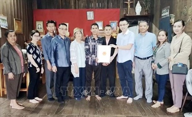 Representatives from the Vietnamese Consulate General in Pakse city present gifts to families of invalids and martyrs in Champasak province. (Photo: VNA) 