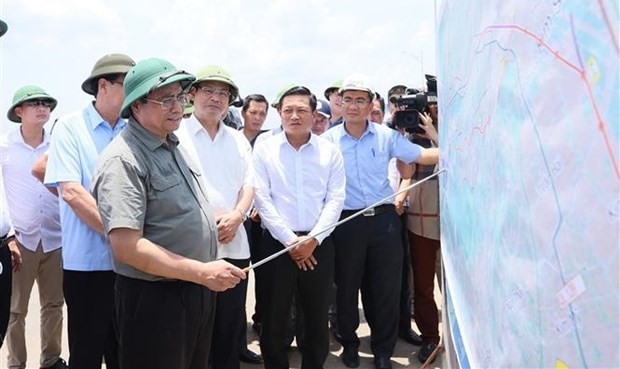 Prime Minister Pham Minh Chinh examines the construction progress of the East-West road project in Ninh Binh province. (Photo: VNA)