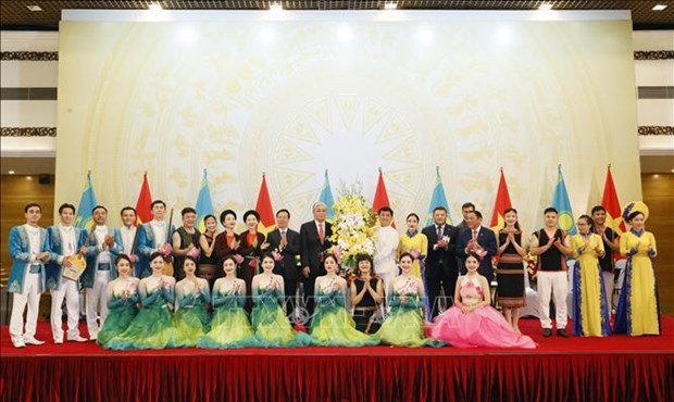 Vietnamese President Vo Van Thuong and Kazakh President Kassym-Jomart Tokayev present flowers to artists who perform at the banquet. (Photo: VNA)