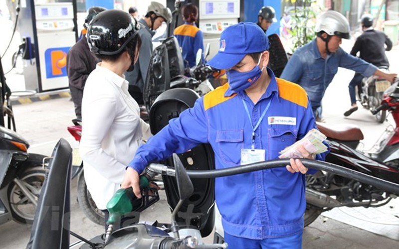 A motorcyclist has her vehicle refilled at a petrol station in Hanoi. 