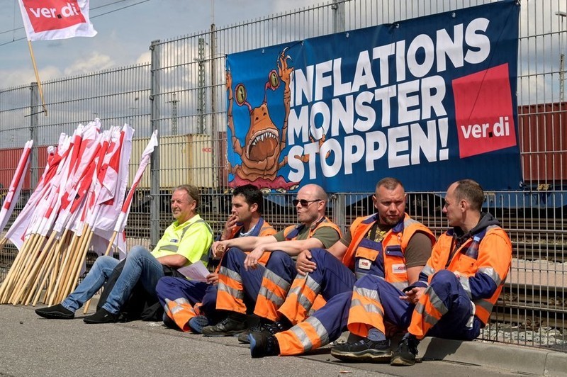 Workers sit in front of a banner reading “Stop the inflation monster” as they strike for higher wages at the port in Hamburg, Germany, June 9, 2022. (Photo: Reuters)