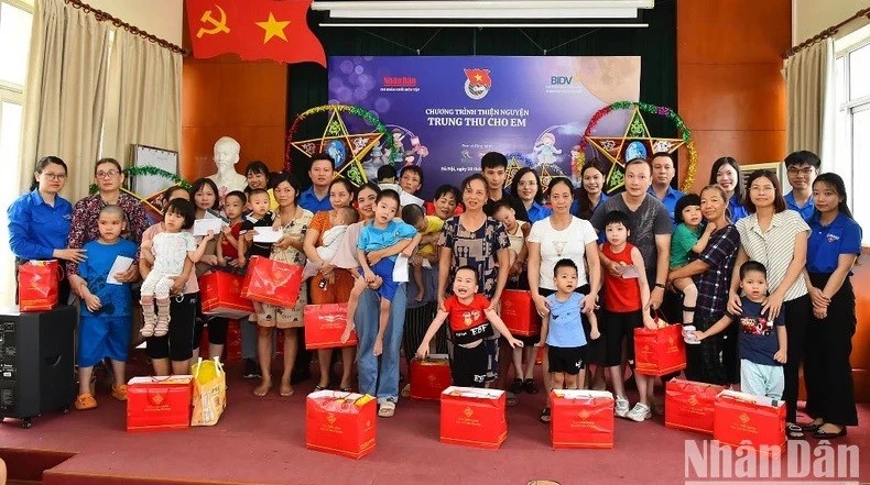 Members of the Youth Union of Nhan Dan Newspaper present gifts to disadvantaged children in Thanh Xuan District, Hanoi. (Photo: NDO/Thuy Nguyen)