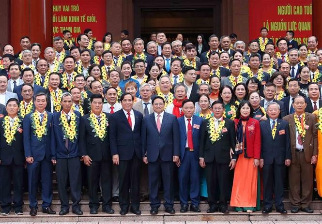 Prime Minister Pham Minh Chinh and the honoured senior citizens pose for a group photo. (Photo: VNA)