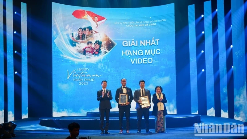 Former Vice President Truong My Hoa and Minister of Information and Communications Nguyen Manh Hung award the First Prize to two authors. (Photo: Trung Hung)