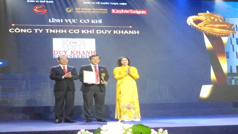 Secretary of the Ho Chi Minh City Party Committee Nguyen Van Nen (left) and Deputy Minister of Industry and Trade Phan Thi Thang present the award to an enterprise.