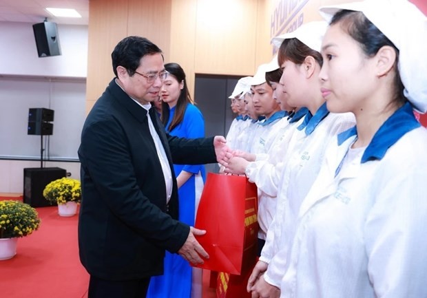 Prime Minister Pham Minh Chinh presents gifts to workers. (Photo: VNA)