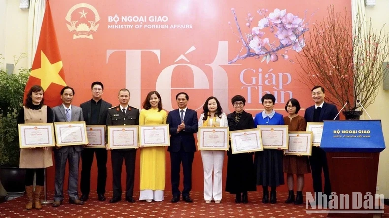 Minister of Foreign Affairs Bui Thanh Son presents the foreign minister’s certificate of merit to several collectives and individuals for their contributions to external affairs over the past year.