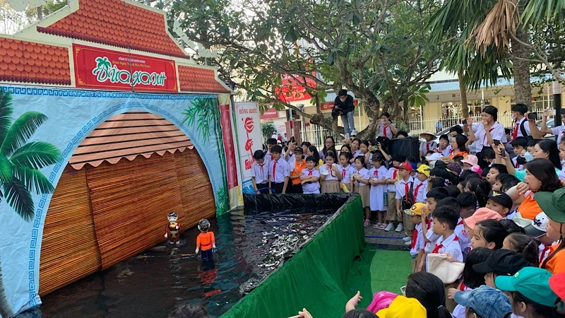 The water puppet show attracts a large number of young spectators.