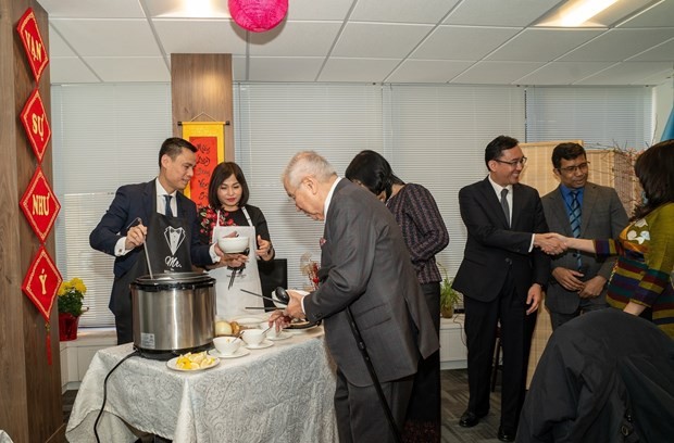 Ambassador Dang Hoang Giang (first, left) and his spouse prepare and introduce traditional Tet dishes of Vietnam to the guests at the event on February 7. (Photo: VNA)
