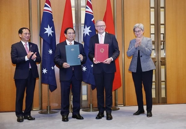 Prime Minister Pham Minh Chinh (second, left) and Australian Prime Minister Anthony Albanese (second, right) exchange the joint statement on the establishment of the Comprehensive Strategic Partnership. (Photo: VNA)