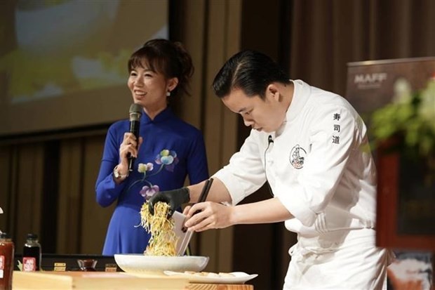 A chef showcases the preparation of Japanese seafood cuisine at the event. (Photo: VNA)