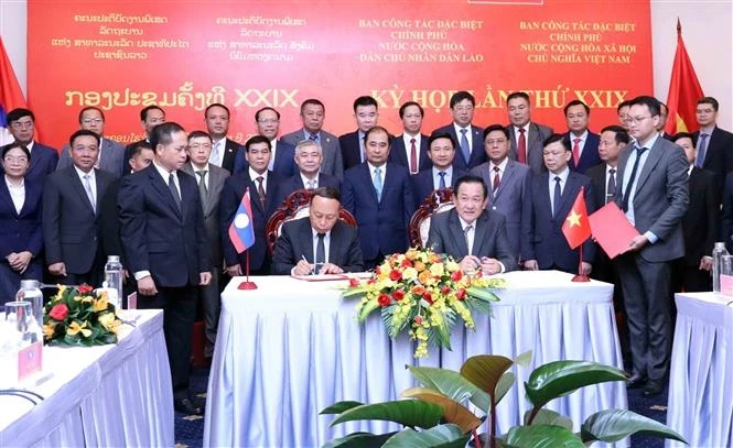 Deputy Minister of National Defence Senior Lieutenant General and the head of the Vietnamese task force Vo Minh Luong (right) and Deputy Minister of National Defence and head of the Lao task force Senior Lieutenant General Thongloi Silivong sign the minutes of the 29th meeting in Ho Chi Minh City on June 24. (Photo: VNA)