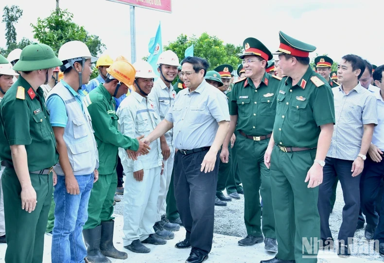 Prime Minister Pham Minh Chinh and officials examine the construction site at Highway 61C intersection in Hau Giang Province’s Phung Hiep district on July 13.