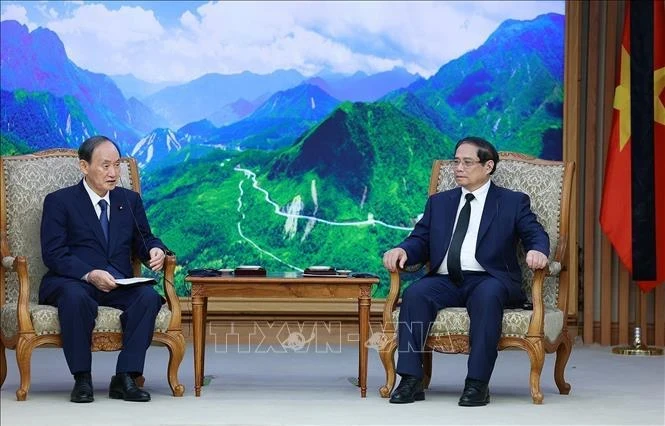 Prime Minister Pham Minh Chinh (R) and Special Envoy of Japanese Prime Minister Kishida Fumio and former Japanese PM Suga Yoshihide at their meeting in Hanoi on July 25 (Photo: VNA)