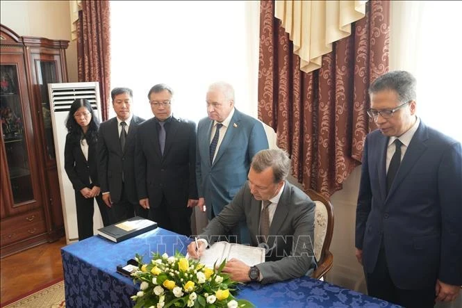 First Deputy Speaker of the Federation Council of the Federal Assembly of Russia Aleksey Yatskin writes in condolence book (Photo: VNA)