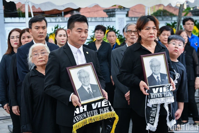 Many people brought portraits of the late Party leader on their way to pay their respects.