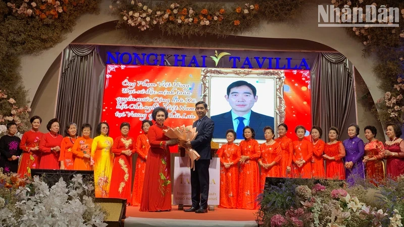 Vietnamese Ambassador to Thailand Pham Viet Hung presents flowers to congratulate Dinh Thi Kim Loan, Head of the Committee on Overseas Vietnamese Women in Thailand, along with members of the Executive Board. (Photo: Xuan Son)