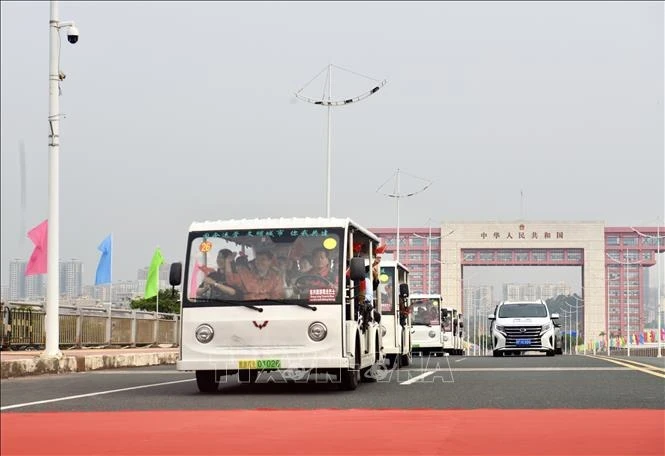 Electric vehicles carrying tourists cross Bac Luan II Bridge, part of the Mong Cai (Quang Ninh, Vietnam) - Dongxing (Guangxi, China) international border gates. (File photo: VNA)