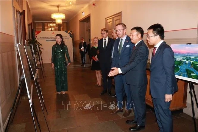 Ambassador Tran Van Tuan introduces the Vietnamese photo exhibition to Swedish Minister for Infrastructure and Housing Andreas Carlson. (Photo: VNA)