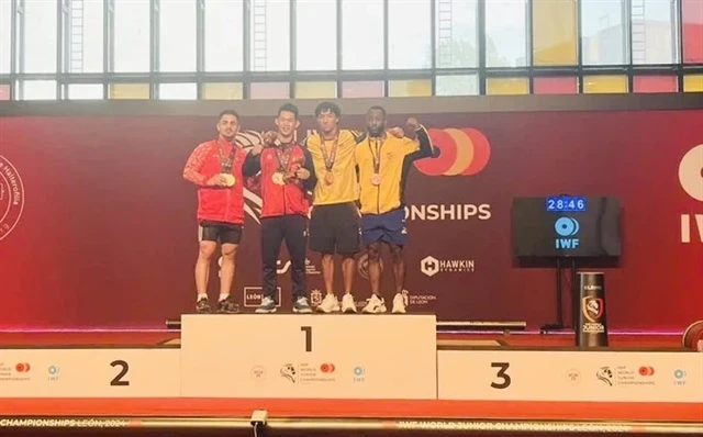 Tran Minh Tri of Vietnam (second left) takes two golds in the men's 67kg class at the World Youth Weightlifting Championships in Spain (Photo: VNA)