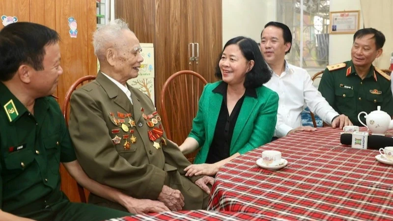 Politburo member and Secretary of Hanoi Party Committee Bui Thi Minh Hoai talks with veteran Nguyen Van Lan.