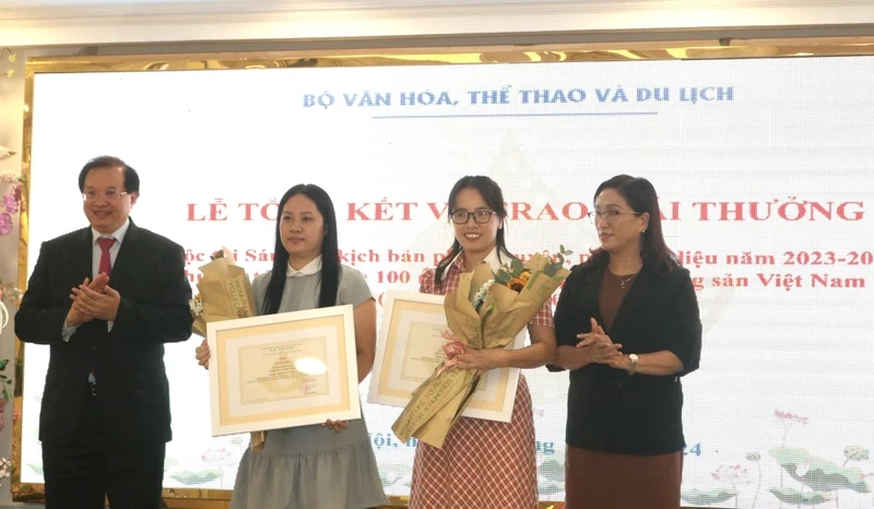 Ta Quang Dong, Deputy Minister of Culture, Sports and Tourism (left), presents awards to outstanding authors.