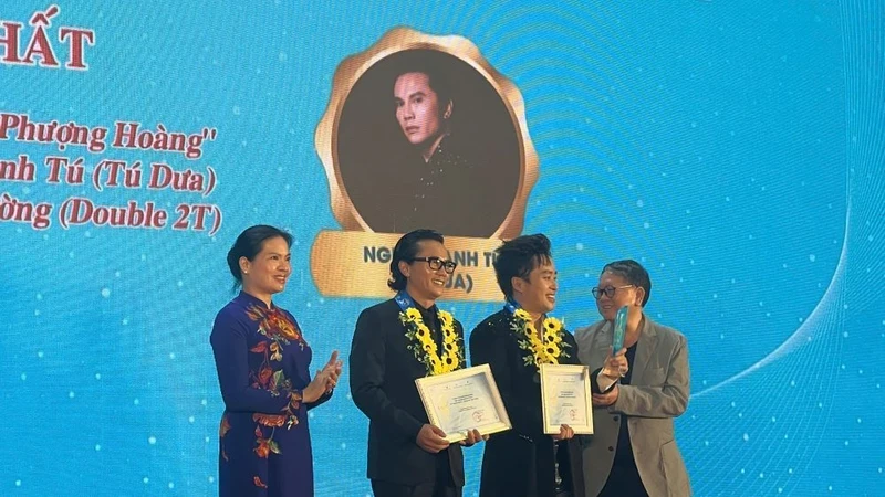 President of the Vietnam Women's Union Ha Thi Nga presents the First Prize to musician Nguyen Anh Tu for his song “Phoenix Wings”.