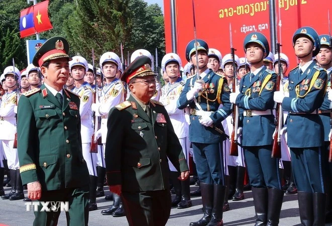 Vietnamese Minister of National Defence Gen. Phan Van Giang (left) and his Lao counterpart Gen. Chansamone Chanyalath inspect the guard of honour at the second Vietnam-Lao border defence friendship exchange on October 22. (Photo: VNA)