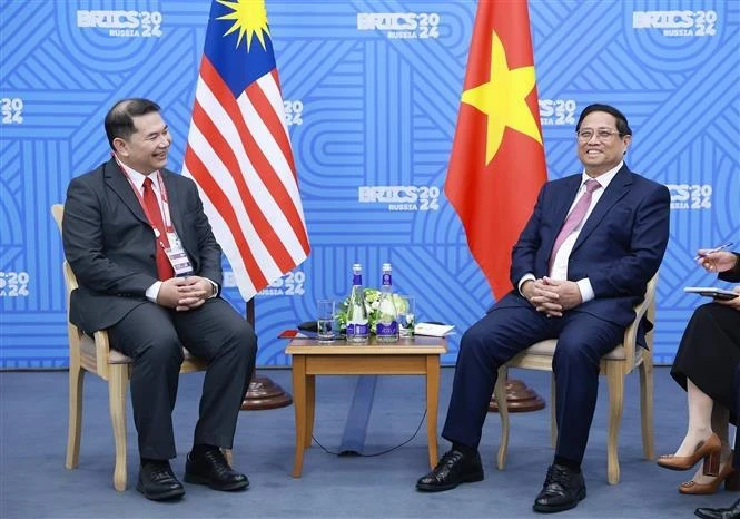 Prime Minister Pham Minh Chinh (R) meets Malaysian Economy Minister Rafizi Ramli on the sidelines of the expanded BRICS Summit in Kazan city, Russia, on October 24 (local time). (Photo: VNA)